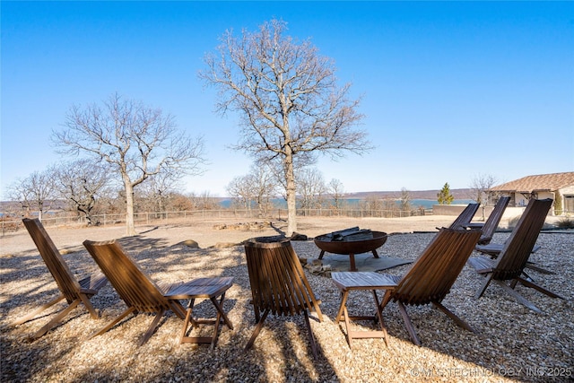 view of yard featuring an outdoor fire pit and fence