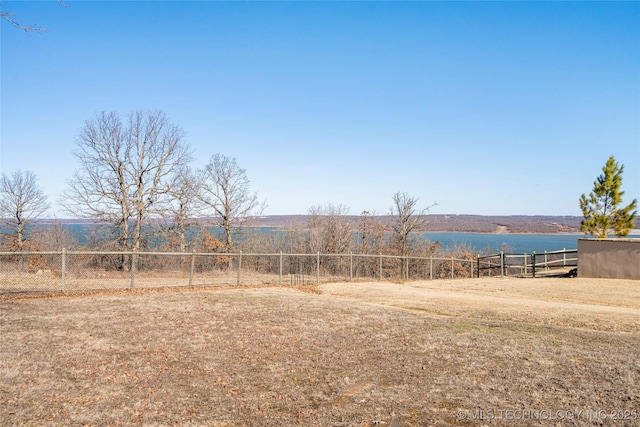 view of yard with a water view and fence