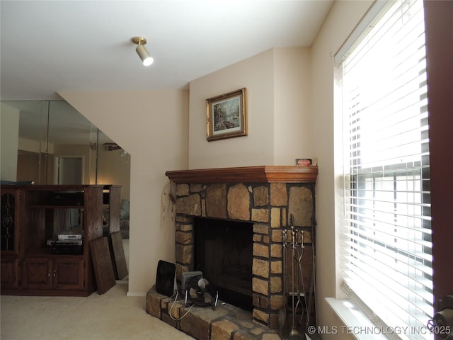 living room with a stone fireplace and carpet