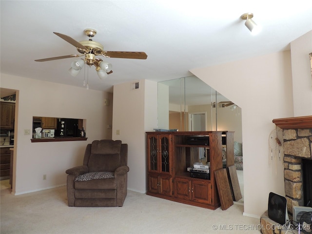 living area featuring a fireplace, visible vents, a ceiling fan, carpet flooring, and baseboards