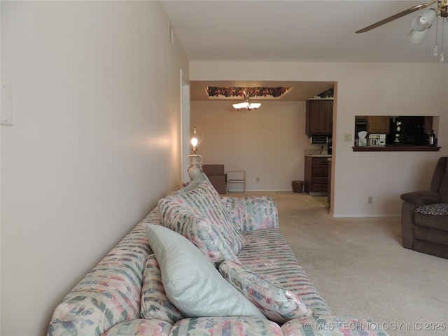 living area with a ceiling fan and light colored carpet