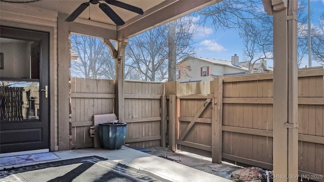 view of patio / terrace with fence, a ceiling fan, and a gate