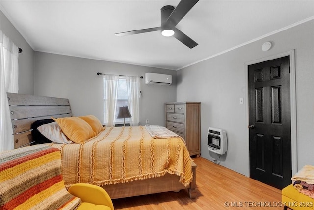 bedroom featuring heating unit, ornamental molding, a ceiling fan, an AC wall unit, and light wood-type flooring