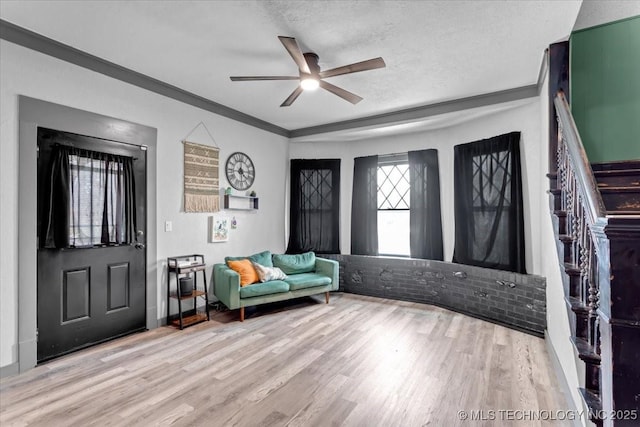 entrance foyer with a ceiling fan, crown molding, a textured ceiling, and wood finished floors