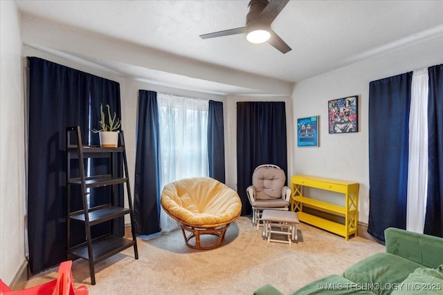 living area featuring carpet floors and a ceiling fan