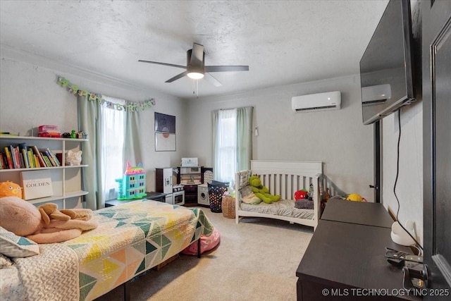 bedroom with a textured ceiling, an AC wall unit, carpet, and a ceiling fan