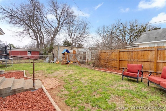 view of yard featuring a trampoline, a playground, and a fenced backyard