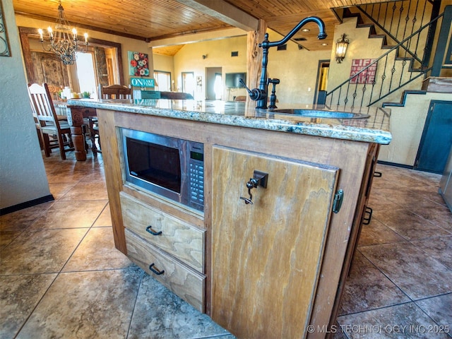 kitchen with lofted ceiling, wood ceiling, stainless steel microwave, an inviting chandelier, and tile patterned flooring