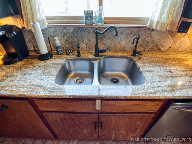 room details with decorative backsplash, a sink, light stone counters, and stainless steel dishwasher