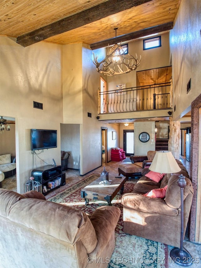 living room featuring wooden ceiling, a notable chandelier, visible vents, and beam ceiling