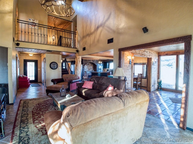 living room with a chandelier, stone tile flooring, stairway, and a towering ceiling