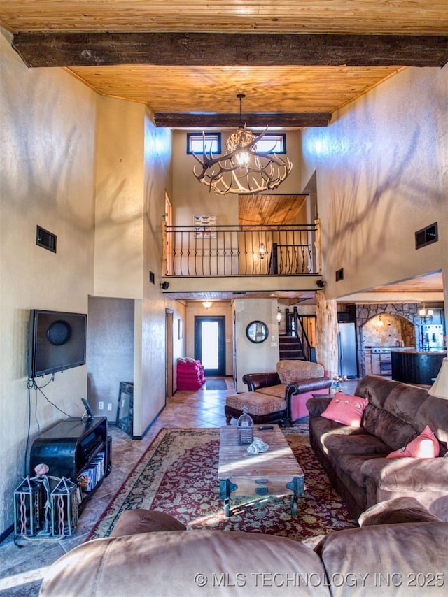 living area featuring a notable chandelier, wood ceiling, visible vents, stairs, and beam ceiling