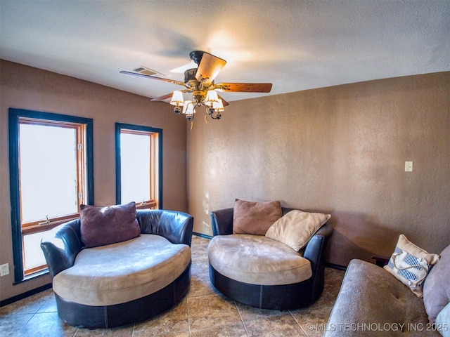 sitting room featuring a ceiling fan and a textured ceiling