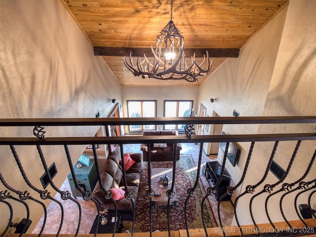 interior space featuring an inviting chandelier, wood ceiling, and beam ceiling