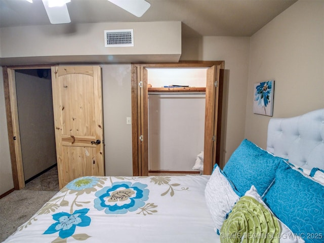 carpeted bedroom featuring a closet, visible vents, and ceiling fan