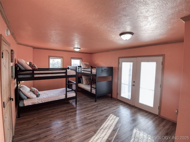 bedroom with french doors, a textured ceiling, and wood finished floors