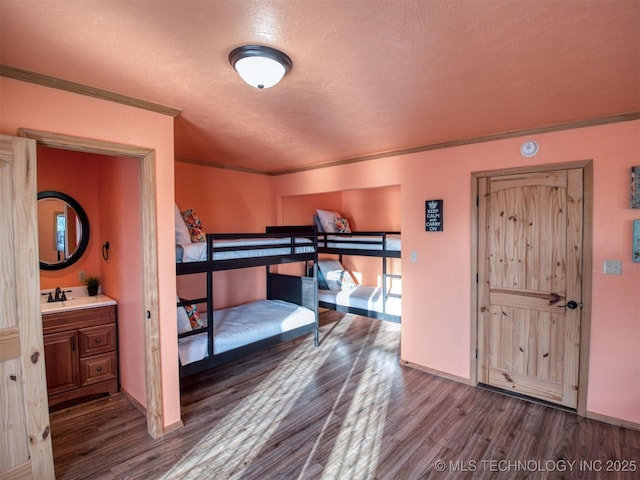 bedroom with dark wood-type flooring, crown molding, and baseboards