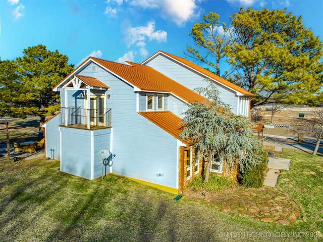 view of home's exterior featuring metal roof and a yard