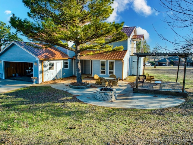 back of property featuring a fire pit, a yard, metal roof, and a patio