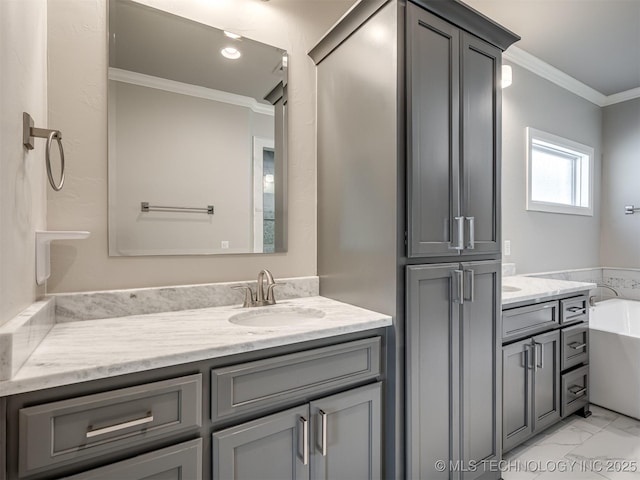 bathroom with marble finish floor, crown molding, vanity, and a bathing tub