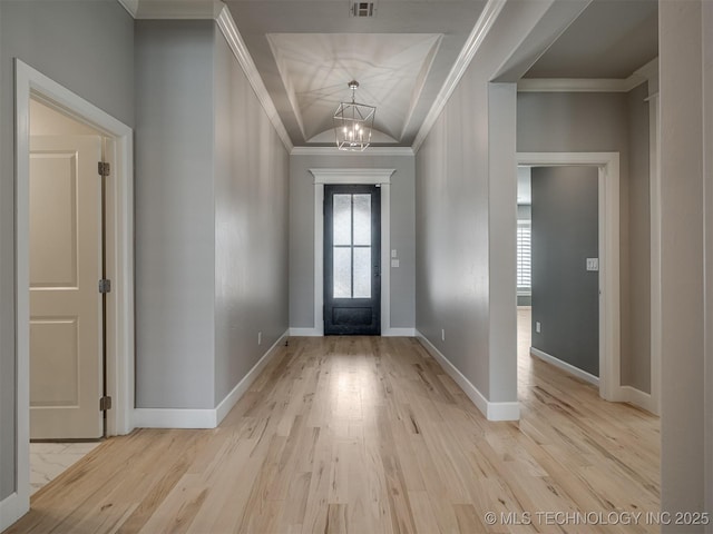 entryway featuring crown molding, a notable chandelier, baseboards, and wood finished floors