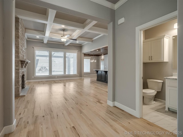 unfurnished living room with a fireplace, coffered ceiling, beamed ceiling, baseboards, and ceiling fan with notable chandelier