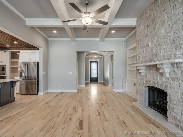 unfurnished living room featuring baseboards, crown molding, a stone fireplace, light wood-type flooring, and beam ceiling