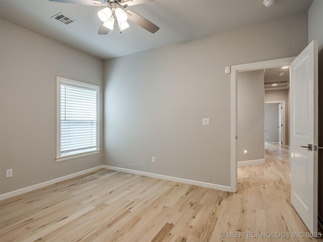 empty room with visible vents, ceiling fan, light wood-style flooring, and baseboards