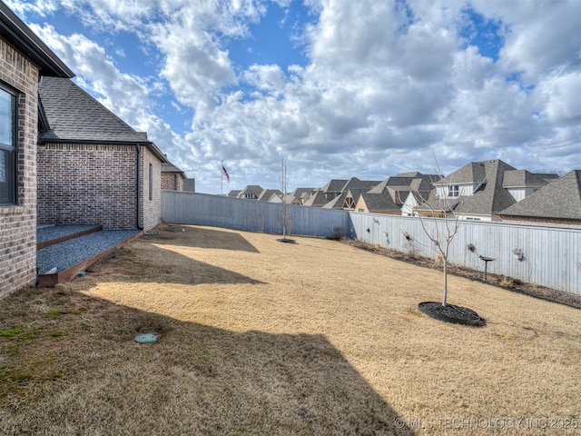 view of yard featuring a residential view and a fenced backyard