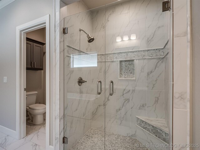 bathroom with marble finish floor, baseboards, toilet, and a marble finish shower