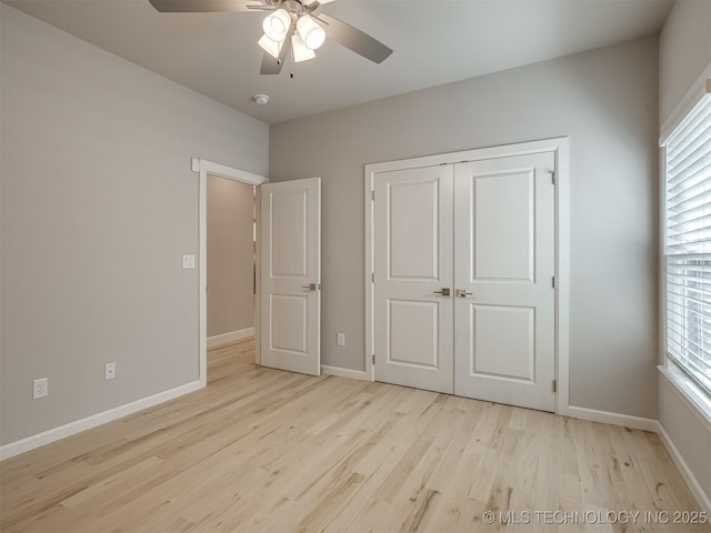 unfurnished bedroom with multiple windows, baseboards, and wood finished floors