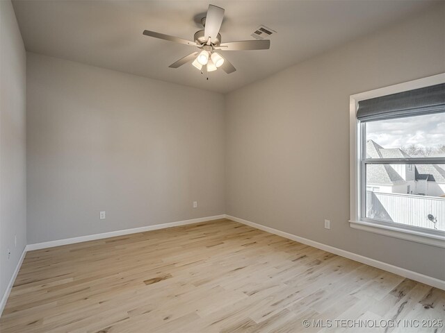 spare room featuring light wood-style flooring, visible vents, and baseboards