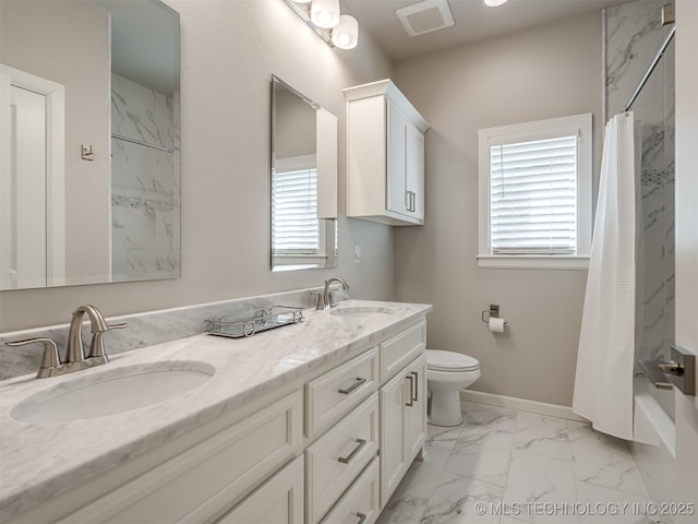 full bath with plenty of natural light, marble finish floor, and a sink