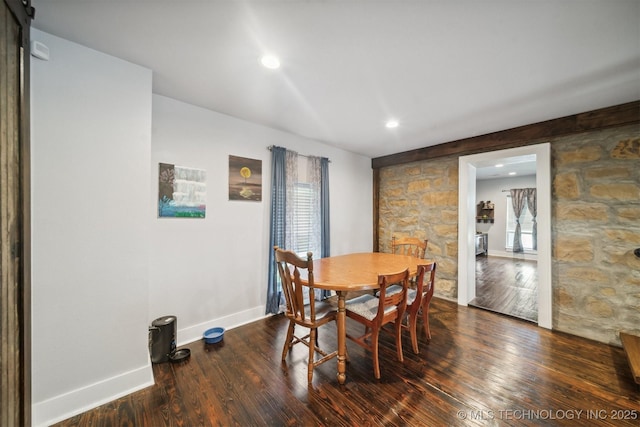 dining room featuring a barn door, recessed lighting, wood finished floors, and baseboards