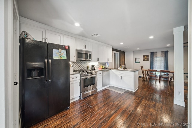 kitchen featuring visible vents, appliances with stainless steel finishes, white cabinets, a sink, and a peninsula