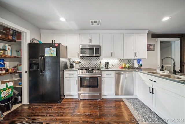 kitchen featuring a sink, visible vents, white cabinets, appliances with stainless steel finishes, and decorative backsplash