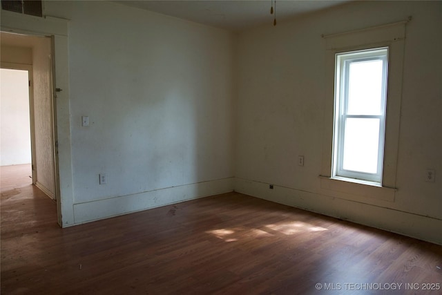 empty room with wood finished floors and visible vents