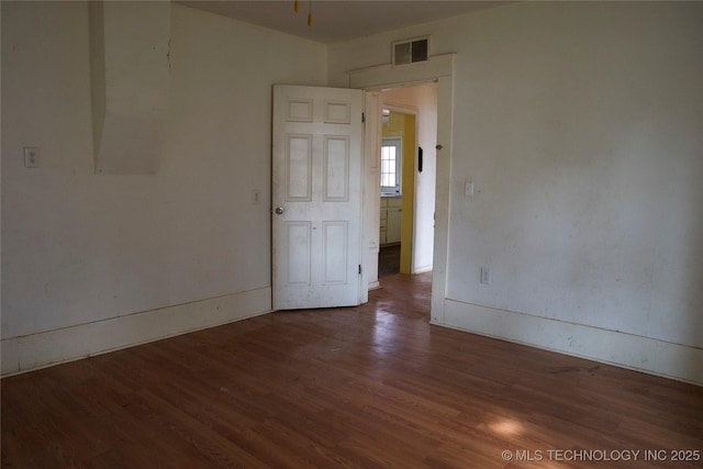 empty room featuring wood finished floors and visible vents