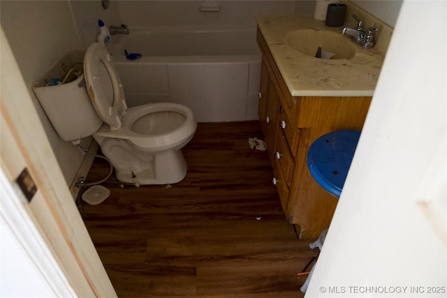 full bathroom featuring a tub to relax in, vanity, toilet, and wood finished floors