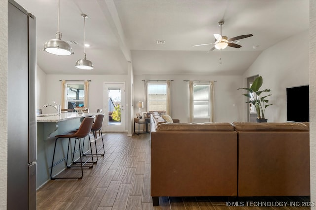 living room with dark wood-style floors, lofted ceiling, visible vents, and a ceiling fan