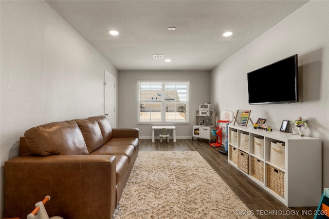 living room with wood finish floors, recessed lighting, visible vents, and baseboards