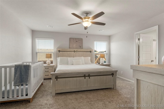 bedroom featuring visible vents, light carpet, and multiple windows