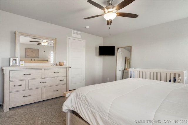 bedroom with visible vents, dark colored carpet, and a ceiling fan