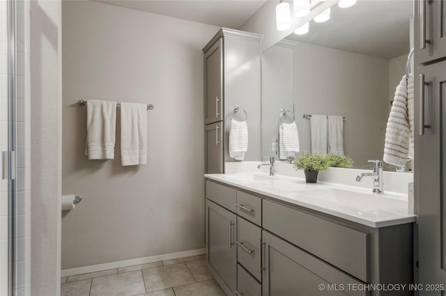 full bath featuring tile patterned flooring, a sink, baseboards, and double vanity