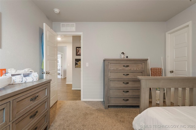 carpeted bedroom featuring visible vents and baseboards