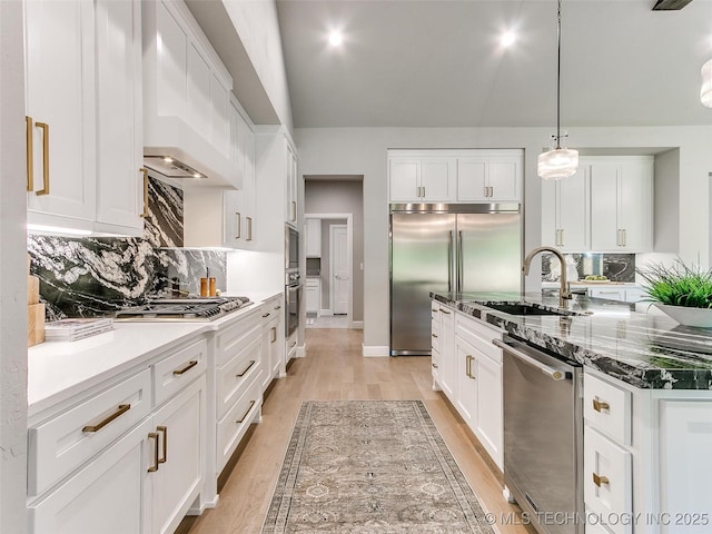 11225 S Fir Ave W, Jenks, OK 74037 - kitchen with white cabinets, decorative backsplash, built in appliances, light wood-type flooring, and premium range hood