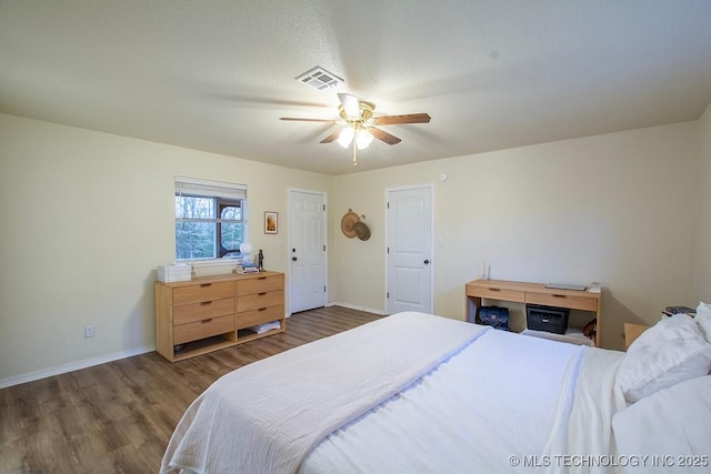 bedroom featuring baseboards, visible vents, ceiling fan, and wood finished floors