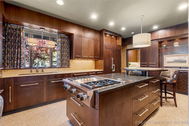 kitchen with recessed lighting, stainless steel gas cooktop, a sink, and a kitchen island