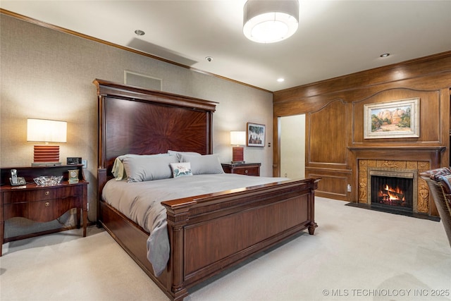 bedroom featuring a warm lit fireplace, light carpet, and crown molding