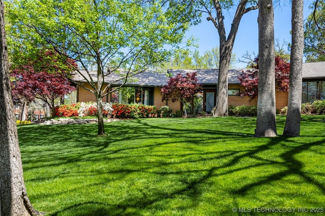 single story home with brick siding and a front lawn